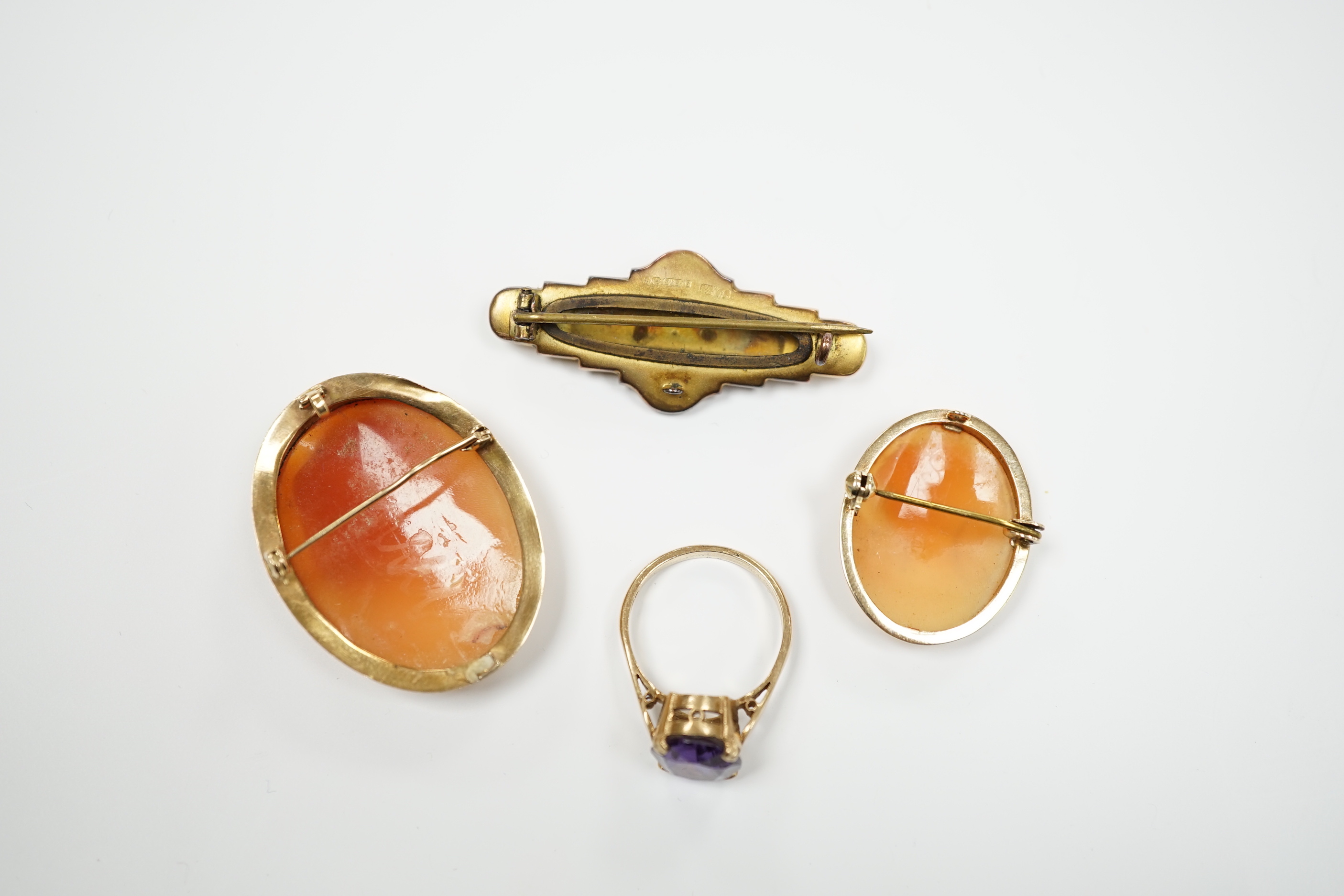 Two 9ct mounted oval cameo shell brooches, largest 38mm, a 9ct and gem set ring and a 9ct gold and gem set bar brooch.